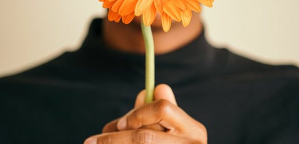 black woman holding orange grbral