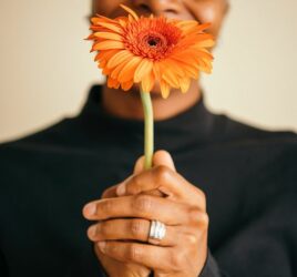 black woman holding orange grbral